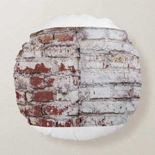 Oud geschilderde bakstenen wand met een witte schi rond kussen
