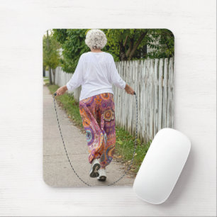 Oude dame springt touw over een trottoir muismat
