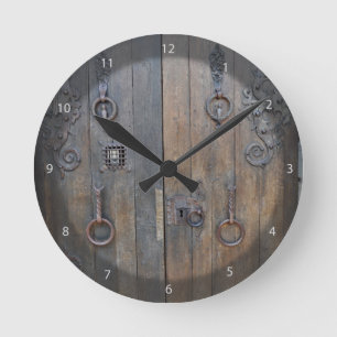 Oude decoratieve houten deur op de stenen wand ronde klok