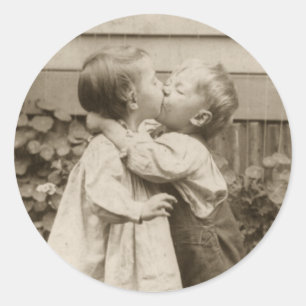 Oude liefdesfoto van kinderen die in een tuin kuss ronde sticker