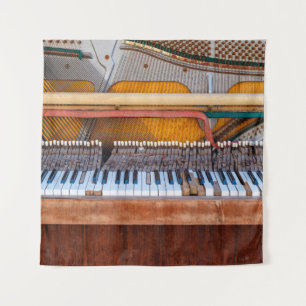 Oude piano met het deksel eraf. Een vervallen Wandkleed