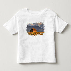 Oude schuur omlijst door hooibalen en dramatisch kinder shirts