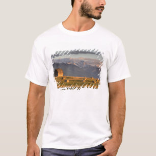 Oude schuur omlijst door hooibalen en dramatisch t-shirt