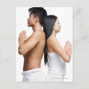 Paar die terug naar achter in yogapositie staan briefkaart