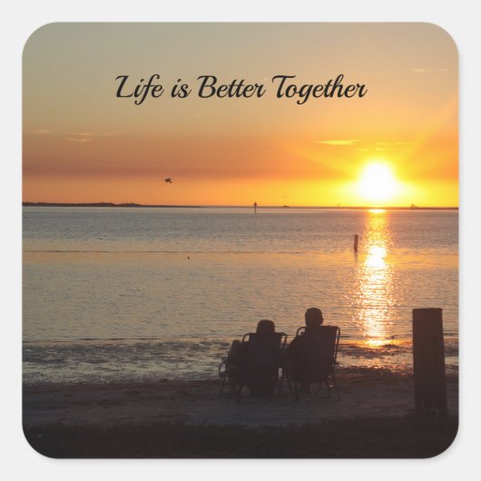Paar zit op strand bij zonsondergang Stickers (Voorkant)