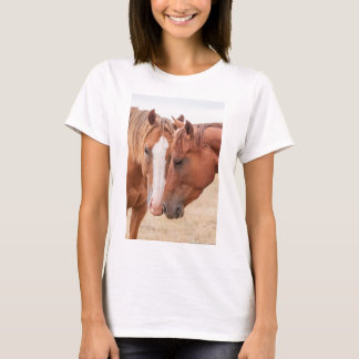 Paarden die elkaar in een wei besnuffelen t-shirt
