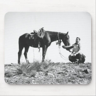 Paarden die eten uit het pet van een cowboy. muismat