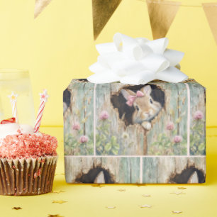 Papier Cadeau Lapin avec un nœud rose pointant d'un trou de clôt