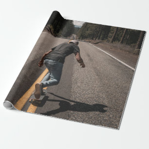 Papier Cadeau Un homme joue au skateboard sur la route le matin