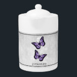 Papillon pourpre fleuri Teapot<br><div class="desc">Profitez de votre thé avec une théière personnalisée à base de papillon violet. Le design de la théière comprend une paire de papillons vibrants reposant sur une vigne florale blanche contre un arrière - plan gris clair. Autres cadeaux disponibles avec ce design ainsi qu'une variété de couleurs.</div>