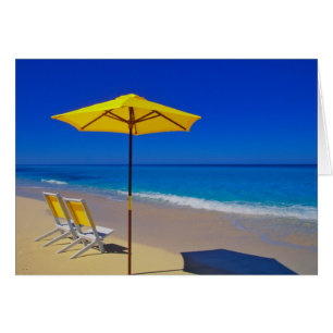 Parapluie de plage jaune et chaises sur plage imma