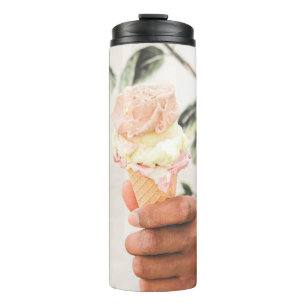 Persoon die consumptie-ijs bevat met drie aroma's  thermosbeker