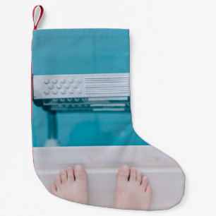 Persoon die op de zwembadladder staat kleine kerstsok
