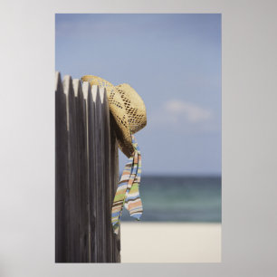 Pet van riem dat op een hek in het strand hangt poster
