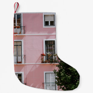 PETITE CHAUSSETTE DE NOËL BÂTIMENT COMMERCIAL EN BÉTON ROSE PRÈS D'ARBRE VER