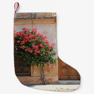 PETITE CHAUSSETTE DE NOËL FLEURS DE PÉTAL ROUGE SUR MUR BÉTON