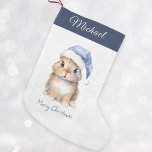 Petite Chaussette De Noël Lapin en Père Noël bleu Casquette Personnalisé<br><div class="desc">Boutique de lapin de Noël Père Noël personnalisée, parfait pour vos petits en cette période de vacances. Cet adorable bas présente un mignon petit lapin portant un casquette Père Noël bleu recouvert de neige. Le stockage peut être personnalisé avec le nom de votre enfant. Accrochez-le sur votre manteau ou dans...</div>