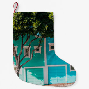 Petite Chaussette De Noël Maisons vertes et bleues à côté des arbres sur le