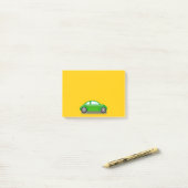 Petite voiture verte sur un Post-It jaune (Sur un bureau)