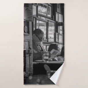 PHOTO GREYSCALE DE MAN SITTING LORS DE LA LECTURE