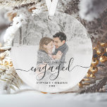Photo personnalisée Premier Noël Engagé Gris Scrip<br><div class="desc">Commémorez votre fiançailles avec ce magnifique ornement de gardien moderne. Le texte gris dit "Notre premier Noël engagé", avec le mot "engagé" dans un élégant script d'écriture manuscrite avec des fioritures avant et après. Remplacez l'exemple d'image par votre photo préférée, et ajoutez vos noms et l'année. Un filtre dégradé blanc...</div>