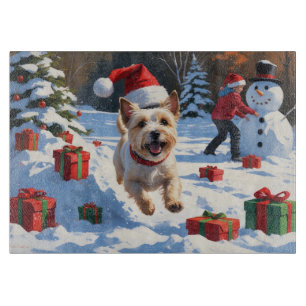 Planche À Découper Cairn Terrier courant dans la neige avec un chapea