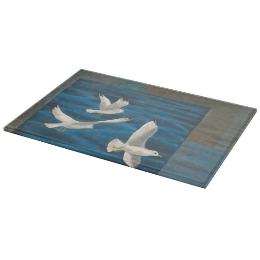 Planche À Découper Trois mouettes blanches volent au-dessus de l'eau (Coin)