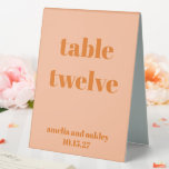 Plaque De Table Gras Peach Orange Retro Numéro de mariage personna<br><div class="desc">Guidez vos invités sans effort avec ce panneau de numéro de table mariage élégant. Dotée d'un design moderne et minimaliste en Peach Orange souple, cette carte recouverte de tentes recto verso est parfaite pour les réceptions, assurant ainsi à chaque table une facilité de recherche. Personnalisez avec les noms et la...</div>