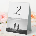Plaque De Table Mariage photo en noir et blanc Numéro de tableau<br><div class="desc">Un magnifique script de calligraphie blanc et noir présentant la photo du couple. Un design photo mariage moderne avec des éléments minimalistes simples. Un design de numéro de table moderne mariage idéal pour toute personne qui aime la calligraphie script, les conceptions noir et blanc et la papeterie photo mariage. Des...</div>