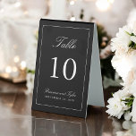Plaque De Table Numéro de table de mariage simple et élégant<br><div class="desc">Un simple design élégant de numéro de table en noir classique avec du texte blanc. Le modèle de texte facile à utiliser a le numéro de table ainsi que les noms de la mariée et de la chambre et la date du mariage. Pour créer un signe de numéro de table...</div>
