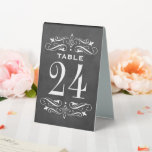 Plaque De Table Vintage Black Chalkboard Mariage<br><div class="desc">Les cartes de numéro de table mariage de style vintage comportent des tourbillons décoratifs et des fioritures qui encadrent le numéro. Décor blanc orné sur un arrière - plan texturé avec un aspect noir tableau noir. Personnalisez chaque carte de numéro de table dont vous avez besoin et ajoutez-la individuellement à...</div>