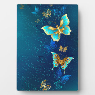 Plaque Photo Papillons d'or sur un Arrière - plan bleu