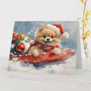 Pomeranian hond in slee laat het sneeuwen Kerstmis Kaart