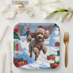 Poodle die in de sneeuw rent met een kerstmuts papieren bordje