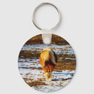 Porte-clés Cheval miniature brun et crème dans la neige.