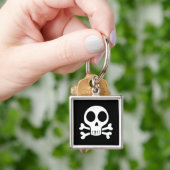 Porte-clés crâne effrayant sur fond noir (main)