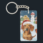 Porte-clés Dachshund Winter Wonderland Christmas Joy<br><div class="desc">Ce design festif reflète l'esprit joyeux de la période des fêtes, avec un adorable petit portant un chapeau de Père Noël. Le chien est niché dans un pays des merveilles hivernales, avec un bonhomme de neige, un sapin de Noël décoré et des cadeaux joliment emballés. Les flocons de neige tombent...</div>
