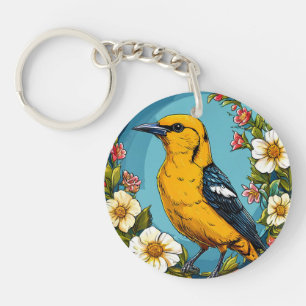 Porte-clés Loriot doré coloré parmi les fleurs épanouies