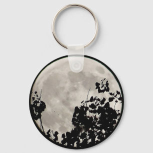 Porte-clés Lune derrière feuilles sombres