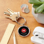 Porte-clés Monogramme classique minimal noir rouge<br><div class="desc">Le porte - clé rond monogrammé minimal dispose d'un arrière - plan noir avec votre initiale dans un médaillon monogramme rouge avec et nom dans la typographie de bloc classique en blanc pour un look professionnel classique simple.</div>