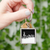 Porte-clés Notes musicales brouillées blanches sur le noir (main)