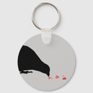 Porte-clés ordre de picotement. oiseau noir et coeurs rouges.