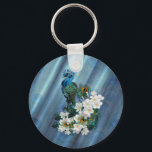 Porte-clés Peacocks & Emerald Green Soie métallique<br><div class="desc">Deux Peacocks impériaux au cou mince se terminant par une longue queue décorative extravagante de plumes impressionnantes enroulées autour de fleurs frangipaniennes blanches parfumées sur un chic vert émeraude soie métallique texturé motif</div>