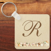 Porte-clés Rangée de coquillages sur le sable de plage avec M (Recto)