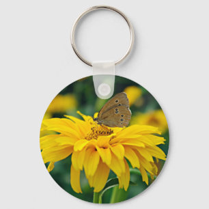 Porte-clés Un papillon sur un porte - clé à fleurs jaunes