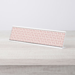Porte-nom Pour Bureau Tissus rouges et roses posés sur un tapis à motif