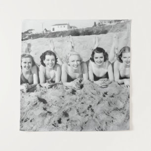 Portret of five young women lying on the beach an wandkleed