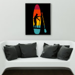 Poster Carte graphique de l'embarquement de la planche à<br><div class="desc">Cette affiche présente l'illustration d'un SUP ou d'une planche à pédales debout et d'une pagaie illustrée en couleurs vibrantes du coucher de soleil avec une illustration en silhouette en noir de quelqu'un qui embarque à la pagaie. Le graphique est défini sur un arrière - plan noir.</div>