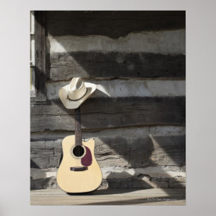 Poster Cowboy casquette sur guitare s'appuie sur le cabin