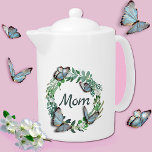 Pretty Wreath with Butterflies Mothers Day Teapot<br><div class="desc">Elegant white tea pot,  with graphics of a pretty plant leaf wreath,  with 3D looking butterflies and green text reading Mom.  Lovely gift idea for mom on Mother's Day.  Matching bone china cup available.</div>